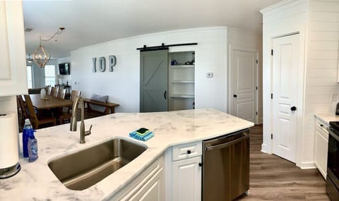 Kitchen with stainless steel appliances and prep island. 208 1140 Ocean Blvd, Isle of Palms, SC | IOP Escapes