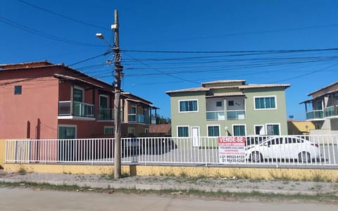 Vista externa do condomínio, com três vagas descobertas para seus veículos no estacionamento