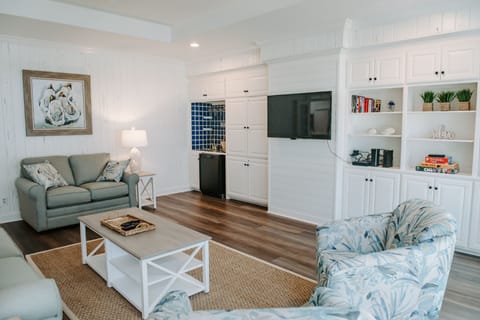 Another view of the den showing the TV, bar and bar refrigerator.