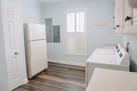 Laundry room has a washer and dryer and another refrigerator, right off kitchen