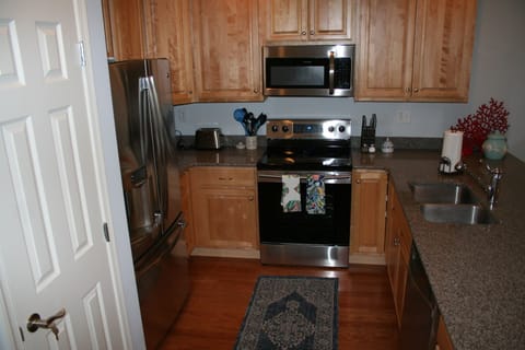 Stocked kitchen with stainless steel appliances, electric stove & dishwasher