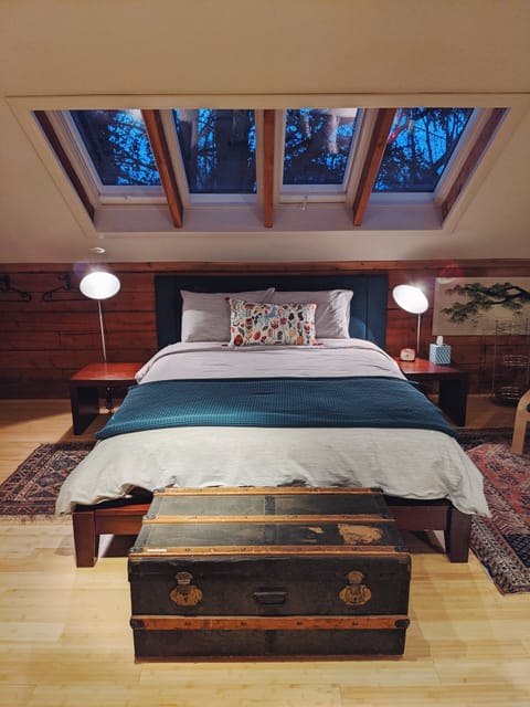 A dreamy bed with a view into the trees.