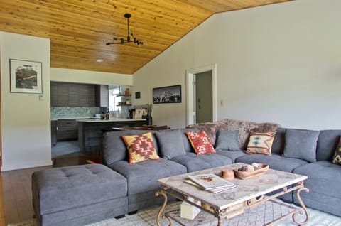 Living room with large sectional sofa, Bose speaker, charging station, and TV
