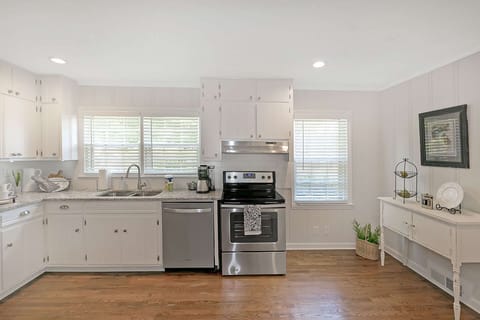 Looking into the kitchen from the breakfast room is the double sink, electric stove with 4 burners and to the right is the door to the formal dinning