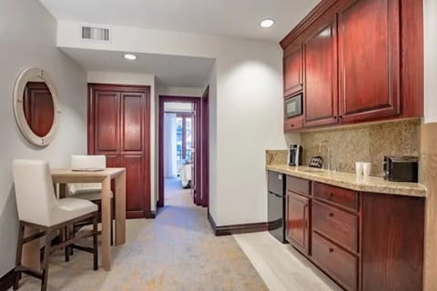 Living room with a kitchenette. Mini refrigerator, microwave, dishes, silverware