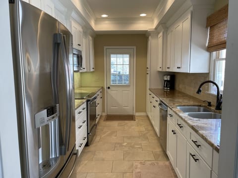Modern upgraded  kitchen with stainless steel appliances and travertine flooring
