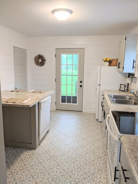 View of kitchen from living room, door to back deck/yard