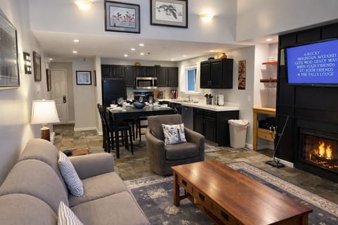 Open-concept living area with a modern fully-equipped kitchen, dining space, and comfortable seating. Perfect for socializing and unwinding after a day on the slopes.