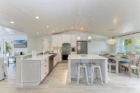 Your coastal-inspired kitchen invites culinary adventures with marble counters, stainless appliances, and a breakfast island perfect for morning coffee conversations.