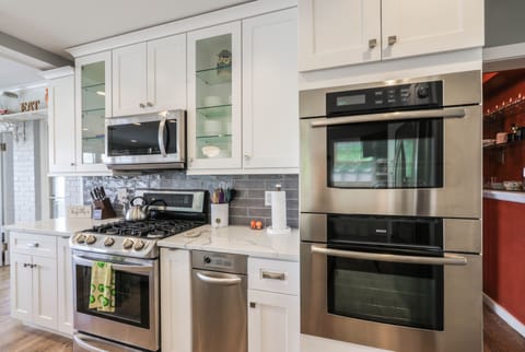 There are three ovens and two refrigerators in this well stocked kitchen.
