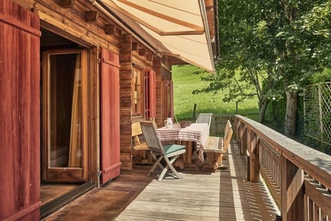 Enjoy the charming wooden balcony with a cozy seating area, perfect for a delightful breakfast.