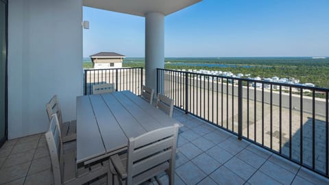 This balcony features a spacious table on the seventeenth floor, perfect for enjoying views of the nearby landscape
