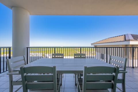 Enjoy expansive views from the spacious balcony, featuring a large dining table and comfortable white chairs