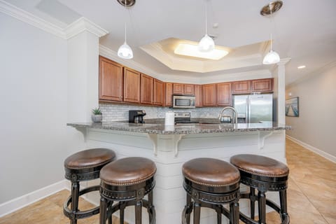 Inviting kitchen featuring granite countertops, stainless appliances, and stylish bar stools for casual dining