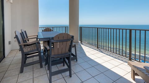 This inviting outdoor dining area features a spacious table and chairs, perfect for enjoying meals with a stunning beach view