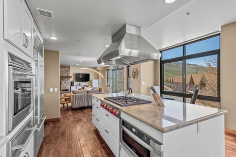The spacious kitchen and freestanding island is facing floor to ceiling windows that have Plaza and mountain views.