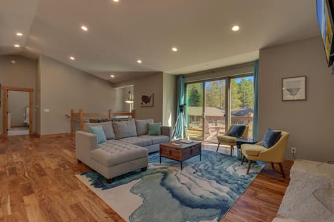 - Spacious living room with modern design  
- Large windows bring natural light and forest views  
- Comfortable seating for gatherings in Tahoe