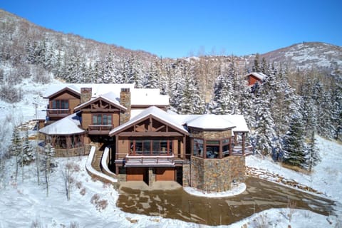 A luxury home blends rustic wood beams and stonework with modern comfort and dramatic views.