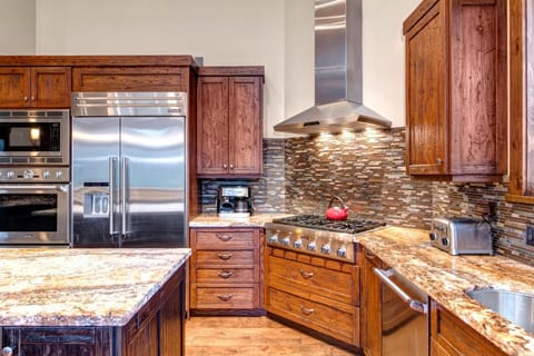 A chef’s kitchen with granite counters and gas range makes meal prep feel effortless.
