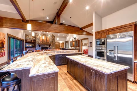 Cook with ease in the open chef’s kitchen with a wraparound island, stainless appliances, and seating for five.