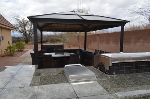 outdoor BBQ area with patio table and couch seating