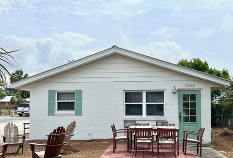 Front patio with dining table and Adirondack chairs. 
