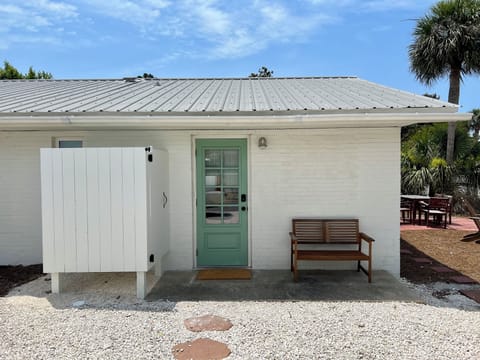 Side door with keypad, gravel parking pad and outdoor shower