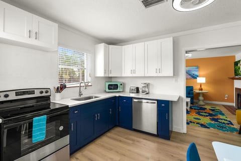 Siesta Key beach retreat kitchen featuring a U-shaped design, colorful details, and modern appliances—styled for effortless prep and breezy coastal living.