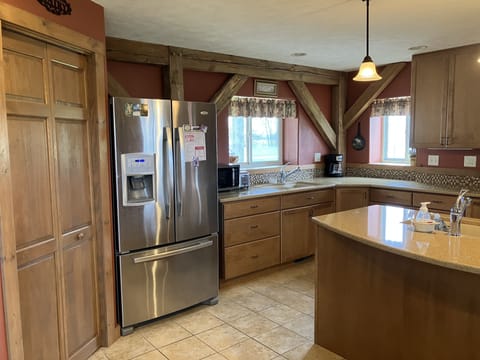 View of kitchen with 2 large sinks, microwave, and coffee pot