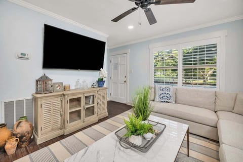 Living room with wall-mounted TV, sofa, and shutters