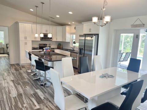 Dinning table with 8 sits overlooking the kitchen island and kitchen area