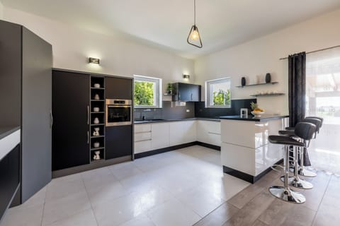 Full equipped kitchen with exit to outdoor dining area.