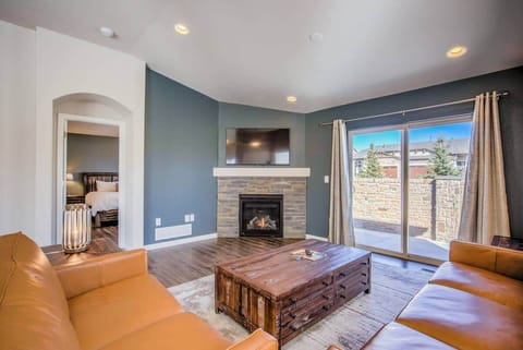 Blue accent wall and a fireplace set the scene in this inviting living room, where leather seating gathers around a wooden coffee table. Natural light pours through the window beside the curtains, creating an easy spot to settle in and unwind.