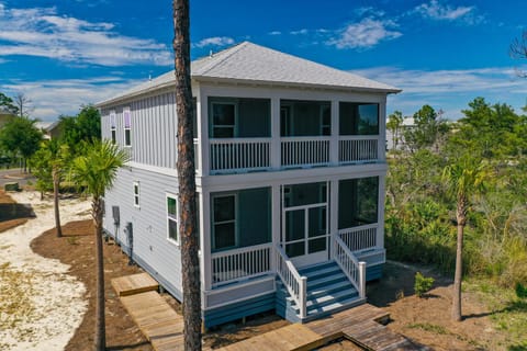 View from the back of the property  highlighting the screen porches available on the main level and second level.