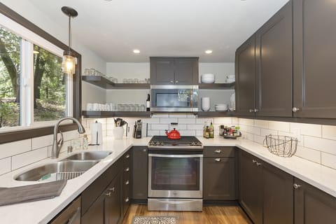 Upgraded appliances and self-closing cabinets, fully stocked kitchen with spices