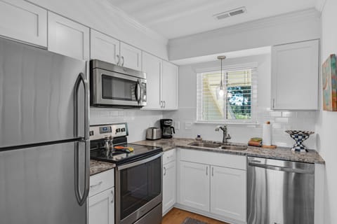 Kitchen has stainless steel appliances, custom cabinetry and granite counters.
