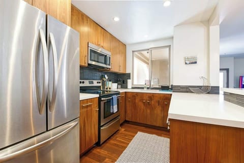 Modern kitchen with sleek stainless steel appliances, warm wood cabinetry, and ample counter space.
