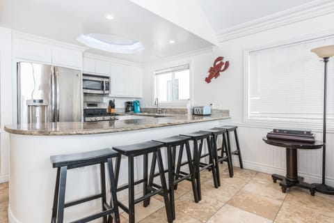 Beyond the living area is the kitchen, with barstool seating for 6, making meal prep a social affair!
                