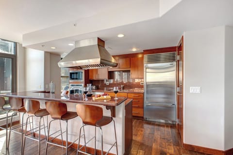 Warm tones in the kitchen with cherry wood cabinets and hardwood floors and red granite countertops