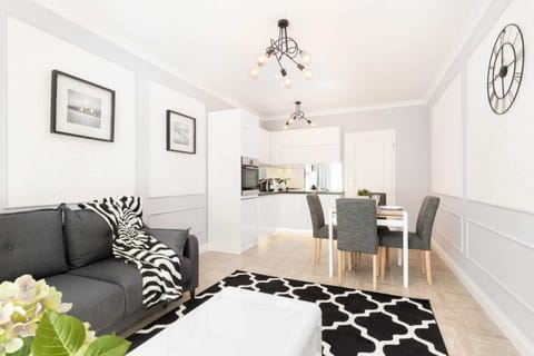 The living room from a different angle, showing its elegant black-and-white patterned decor and access to the dining area.
