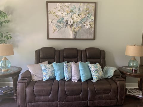 Spacious great room with recliners and a lot of natural light.