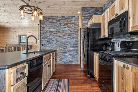 Cook your favorite meals in this rustic-modern kitchen featuring warm wood cabinets and stunning stone accents.