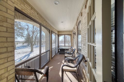 Screened in porch with fire table and view of open yard and orchard
