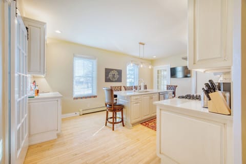 Fully stocked kitchen with beverage center, island with sink, and TV.