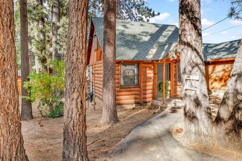 Welcoming cabin entry surrounded by towering pine trees, offering fresh mountain air and a peaceful forest setting—the perfect first impression for your Big Bear Lake getaway.
