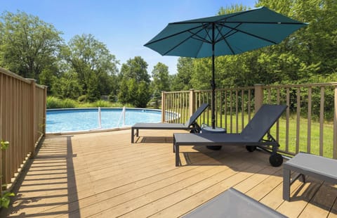 Huge 30 ' round pool, 4 loungers, and umbrella