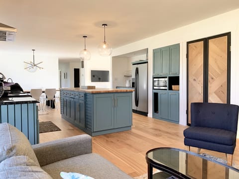 Pantry cabinets surround microwave, bar beside fridge…