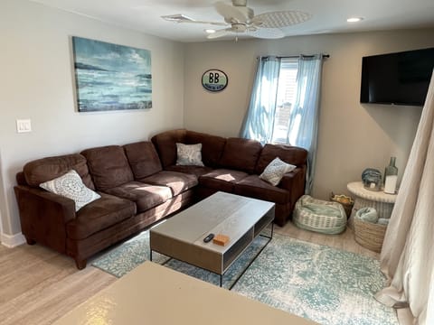 Open concept living room with smart TV, and lift-top coffee table.