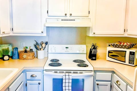 The kitchen features a range, microwave, drip coffee maker and keurig coffee maker.