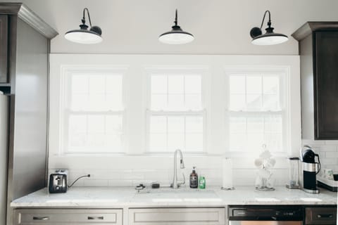 Large counter and sink overlooking fenced in back yard. 